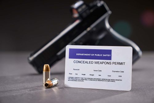 Concealed Carry Permit next to self-defense bullets and a handgu